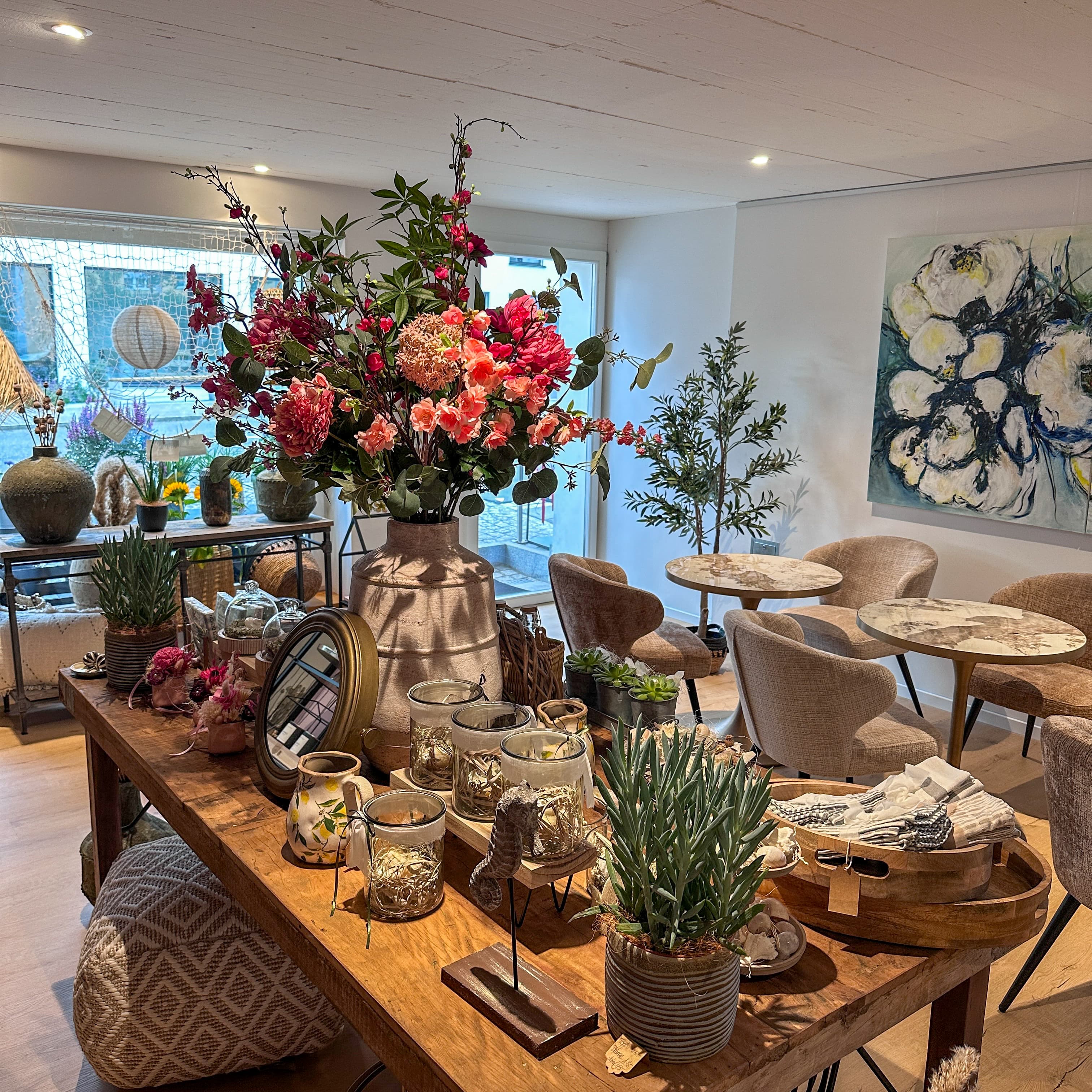 Bistrobereich von Strada 5 mit Blumen, Accessoires und kleinen Tischen