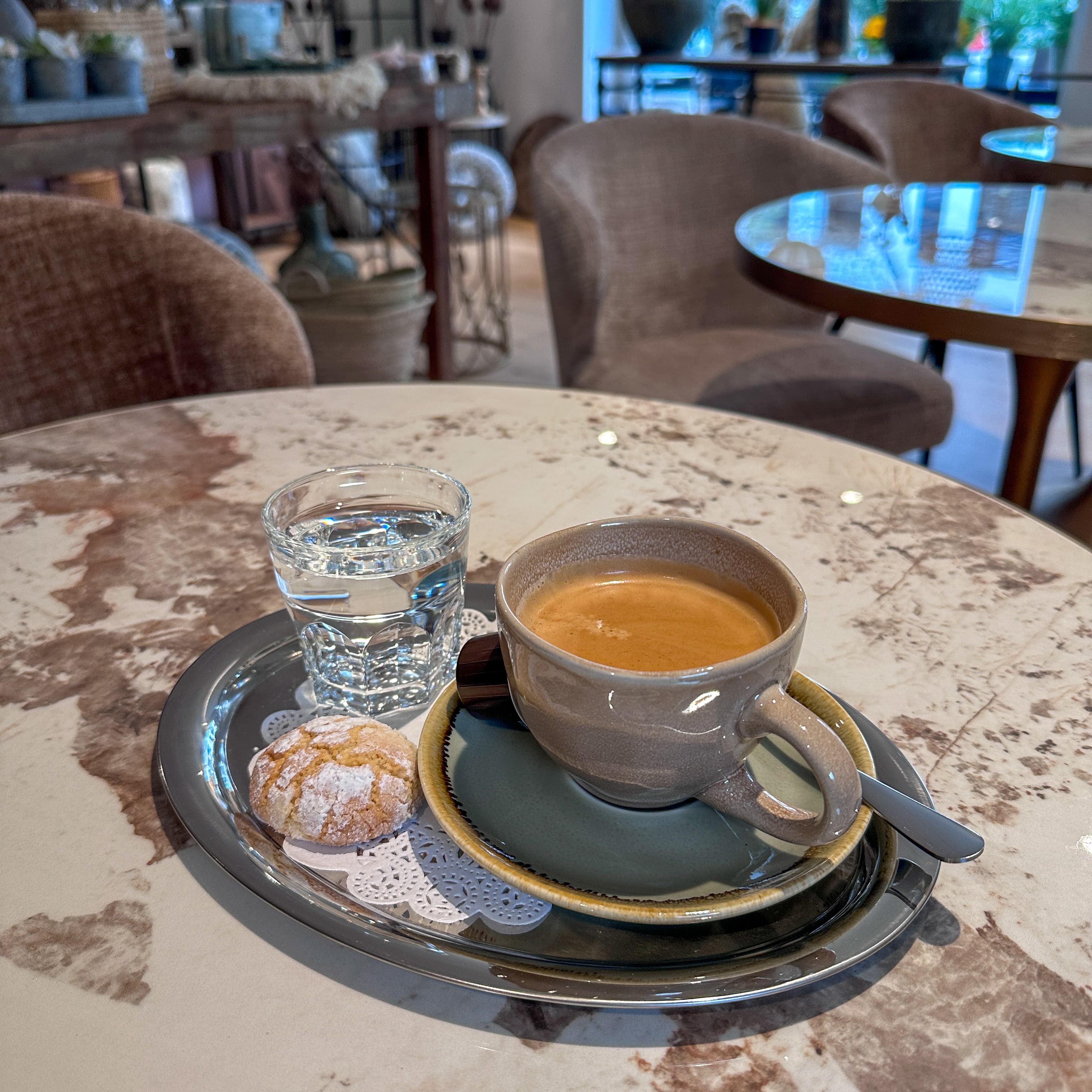 Kaffee, Wasser und Gebäck auf einem Marmortisch im Strada 5